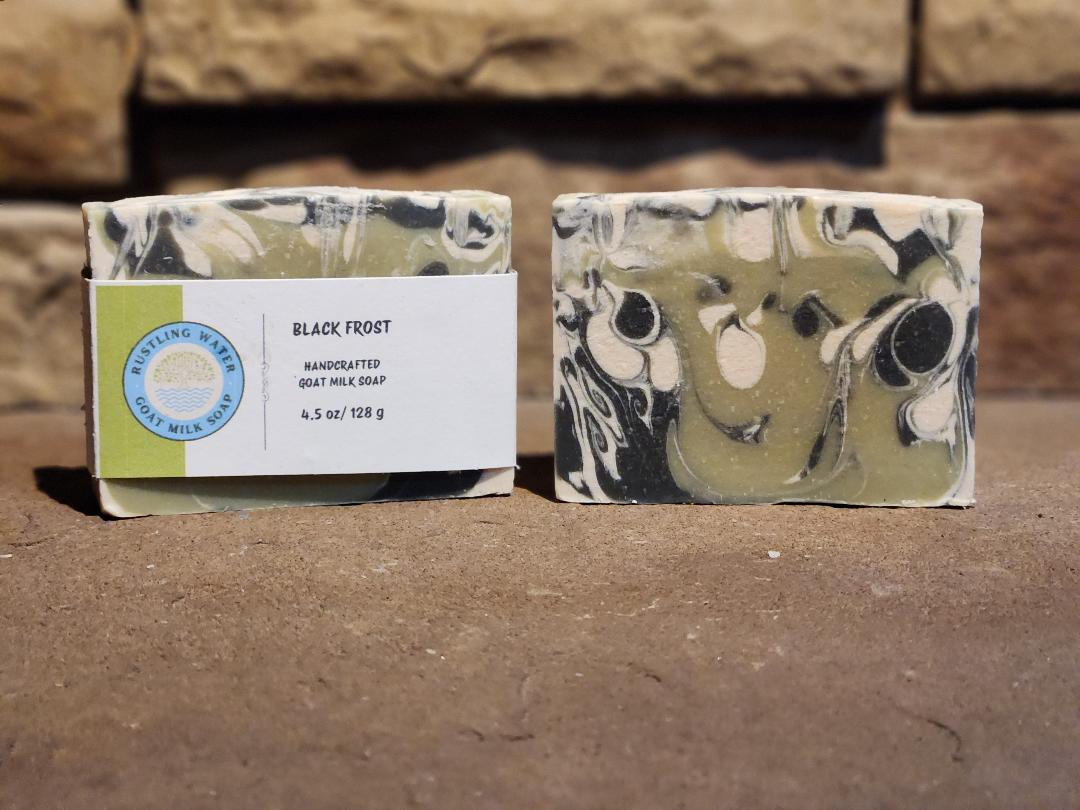 Two bars of soap with a label on a stone surface