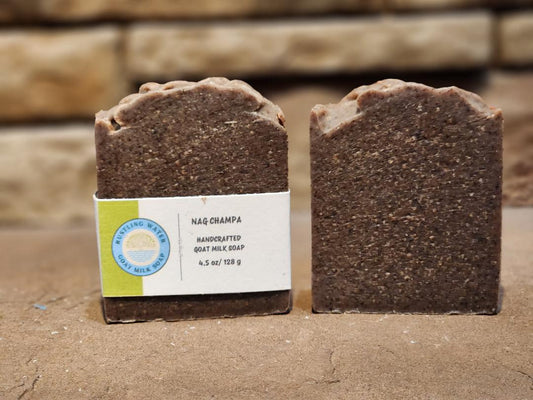 Two bars of brown colored soap with a stone background.